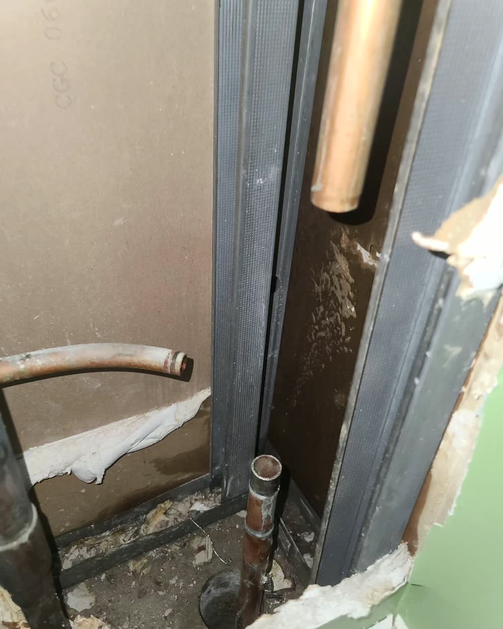 An opened wall exposing copper supply lines for repair